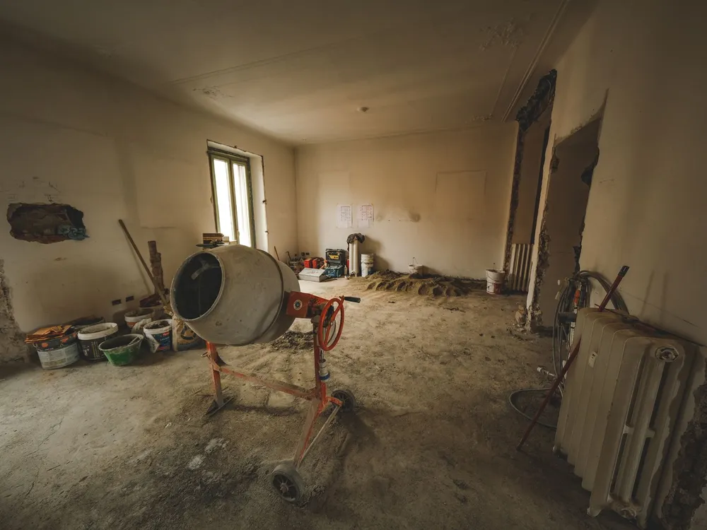 Intérieur d'une ancienne maison en cours de rénovation, bétonnière et matériaux de maçonnerie au sol
