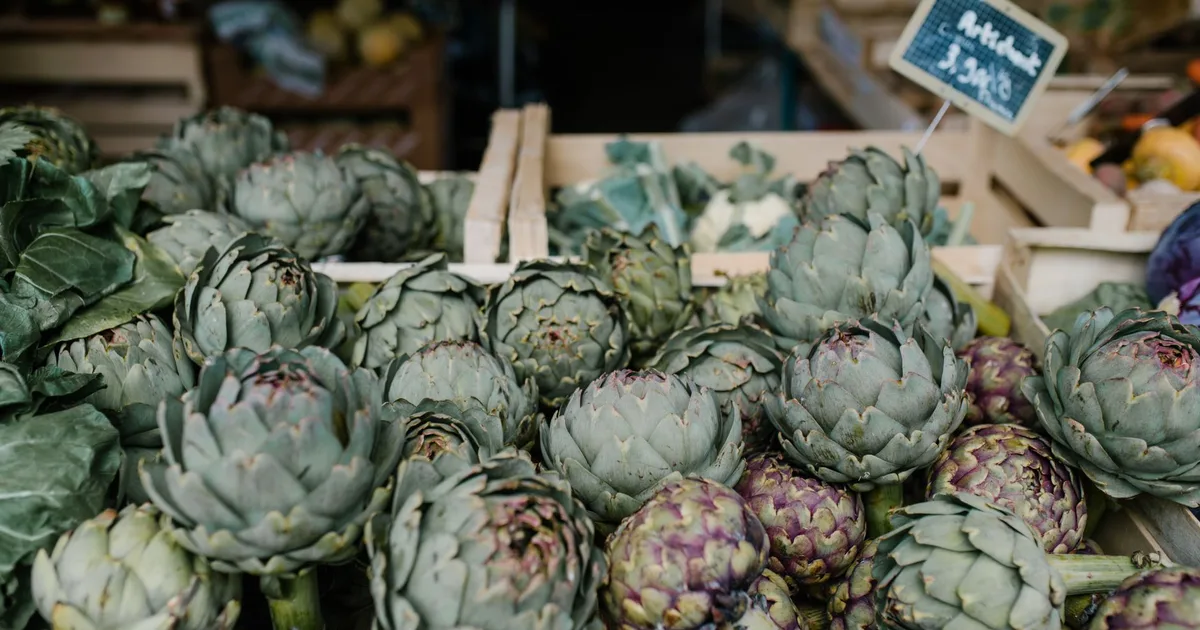 Étals de légumes bio et de producteurs locaux sur un marché breton, cagettes en bois et légumes de saison