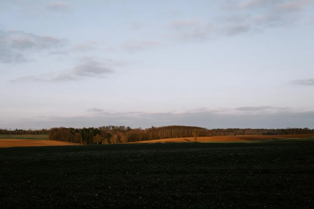 Lumière dorée de fin d'après-midi de septembre sur une cour de ferme bretonne