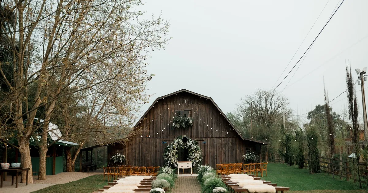 Grange en bois aménagée pour une cérémonie de mariage en plein air, allée fleurie